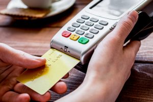 Credit card being inserted into a card reader, PCI compliance